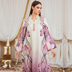 Women's floral kaftan dress with pink flowers, V-neck, and fringe tassels in elegant setting