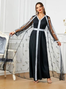 Detail of elegant black two-piece dress with silver feather embroidery and lace trim