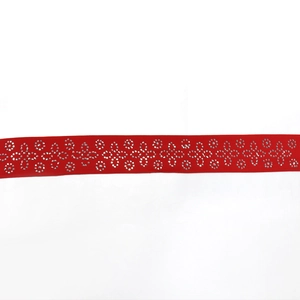 Vue macro d'un ruban satin rouge avec motif floral en strass argentés pour robes de soirée