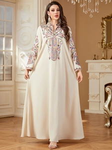 Détail de la broderie ethnique sur une robe longue caftan beige à col en V profond