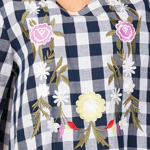 Women's long sleeve gingham dress featuring colorful floral embroidery on the neckline