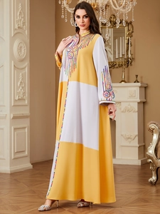 Exquisite embroidery detail on a yellow and white color-block long sleeve kaftan maxi dress