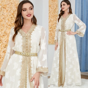 Detailed view of white long sleeve dress with golden embroidery and braided belt