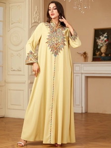 Détail de la broderie colorée et des sequins sur la robe longue Jalabiya jaune clair