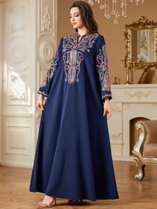 Détail de la broderie de paillettes colorées sur cette robe longue ethnique bleu marine