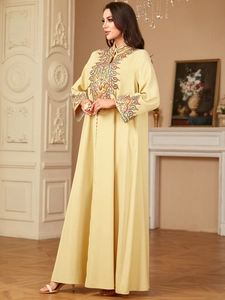 Détail de la broderie ethnique colorée sur la poitrine d'une robe jalabiya jaune pâle