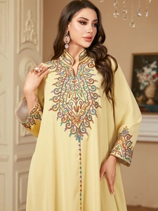 Détails de broderie florale colorée sur la robe Jalabiya jaune à manches longues