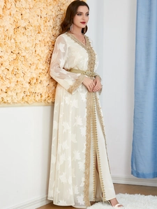 Detail of white kaftan with gold floral embroidery and matching decorative waist belt
