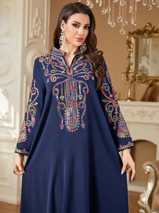 Détail de broderie de sequins colorés sur une robe caftan ethnique bleu foncé