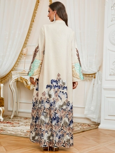Detail of elegant cream maxi abaya with intricate blue floral prints on sleeve and hemline