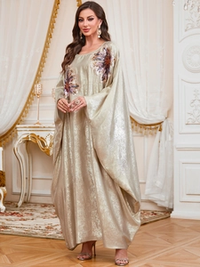Detailed view of champagne gold dress with sequin floral embroidery and batwing sleeves