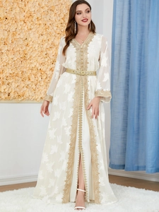 Detail of white Moroccan kaftan with gold embroidery and intricate metallic belt