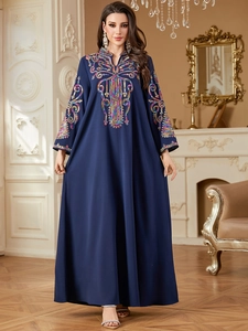 Détails de broderie ethnique colorée et de paillettes sur robe longue caftan bleu marine