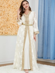 Detail of white V-neck kaftan dress with gold embroidery and decorative chain belt
