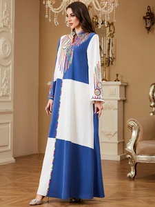 Detail of color-block dress with intricate embroidery on neckline and cuffs
