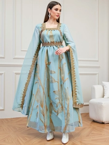 Detail of light blue kaftan with golden leaf embroidery and elegant cape sleeves