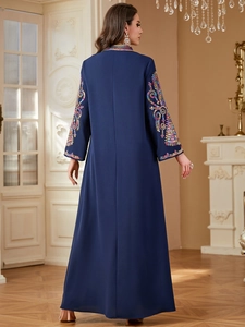 Détail de broderies à paillettes sur les manches d'une robe longue ethnique bleu marine