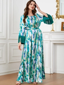 Détails d'une robe longue à imprimé artistique avec poignets à franges vertes et ceinture