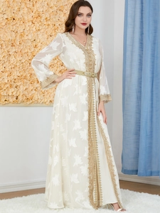 Detail view of intricate gold embroidery on the neckline of a white V-neck Kaftan dress