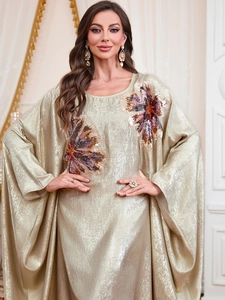 Detail of sequin floral appliques and metallic texture on luxury gold maxi dress