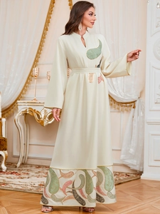 Détails de broderie paisley sur une robe longue ethnique jalabiya beige à col en V