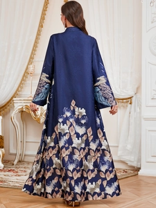 Detail view of navy blue kaftan featuring intricate leaf prints on cuffs and hem