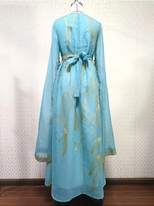 Close-up of golden leaf embroidery on light blue chiffon dress with lace cuffs