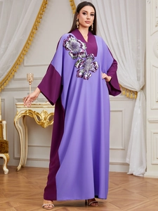 Detail of sequin flower embroidery and color block design on the purple kaftan robe