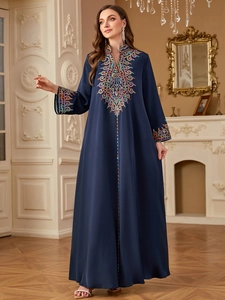 Détails de broderie colorée sur robe jalabiya bleu marine avec manches longues élégantes