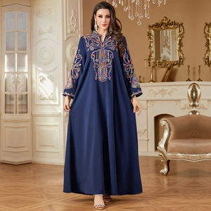 Robe caftan bleu marine avec broderie ethnique et paillettes dans un salon vintage