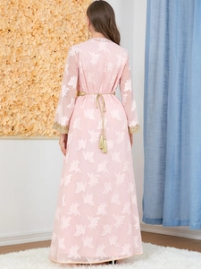 Rear view of pink long sleeve dress with white floral embroidery and gold tassel belt