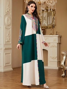 Detailed view of colorful ethnic embroidery and beadwork on a green patchwork robe