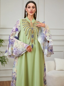 Detail of beaded embroidery on a V-neck light green abaya with purple floral flare sleeves