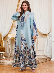 Detailed view of luxury light blue kaftan dress with gold embroidery and silk-like finish