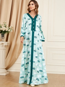 Close-up of elegant V-neckline with pearl buttons on a tropical leaf print dress