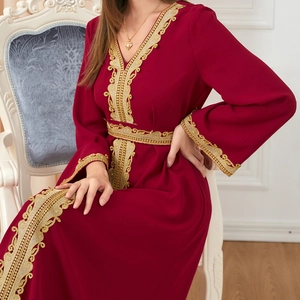 Detail of elegant dark red long dress featuring golden lace embroidery on waist and sleeves