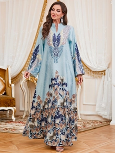 Detailed close-up of light blue abaya dress featuring intricate peacock and floral prints