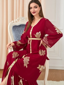 Detailaufnahme der goldenen Blumenstickerei und des V-Ausschnitts am roten Kaftankleid