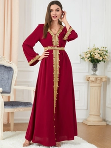 Detail of burgundy kaftan dress with intricate gold embroidery on the V-neck and sleeves