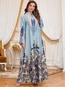 Detail view of light blue printed kaftan dress showing V-neck and phoenix feather patterns