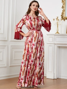 Détail de la robe à imprimé abstrait avec des franges rouges sur les manches longues évasées