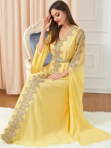 Detail of yellow chiffon kaftan with intricate gold embroidery and luxury beadwork decor
