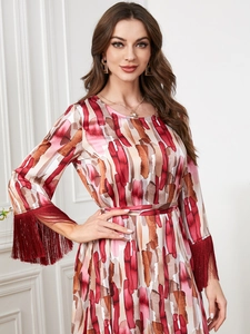 Détail d'une robe à manches longues avec poignets à franges et imprimé artistique abstrait