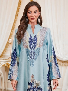 Detail of light blue kaftan dress showing elegant V-neck and intricate pearl embroidery