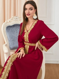 Close-up of golden lace embroidery and V-neck details on a dark red Kaftan dress