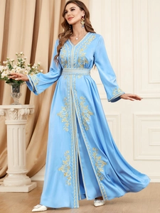 Detail of light blue satin dress featuring intricate gold floral embroidery on sleeves