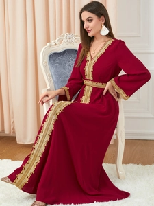 Detail of golden lace embroidery on elegant wine red kaftan dress with waist belt