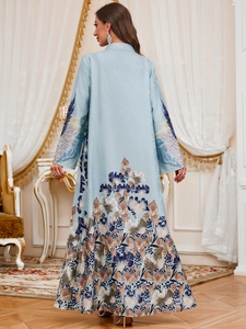 Detail of floral printed hem and cuffs on a light blue flowy long kaftan dress