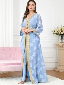 Detail of light blue kaftan with gold embroidery, sequins and white floral patterns