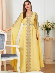 Detailed embroidery on bright yellow Moroccan kaftan with sequined long cape sleeves